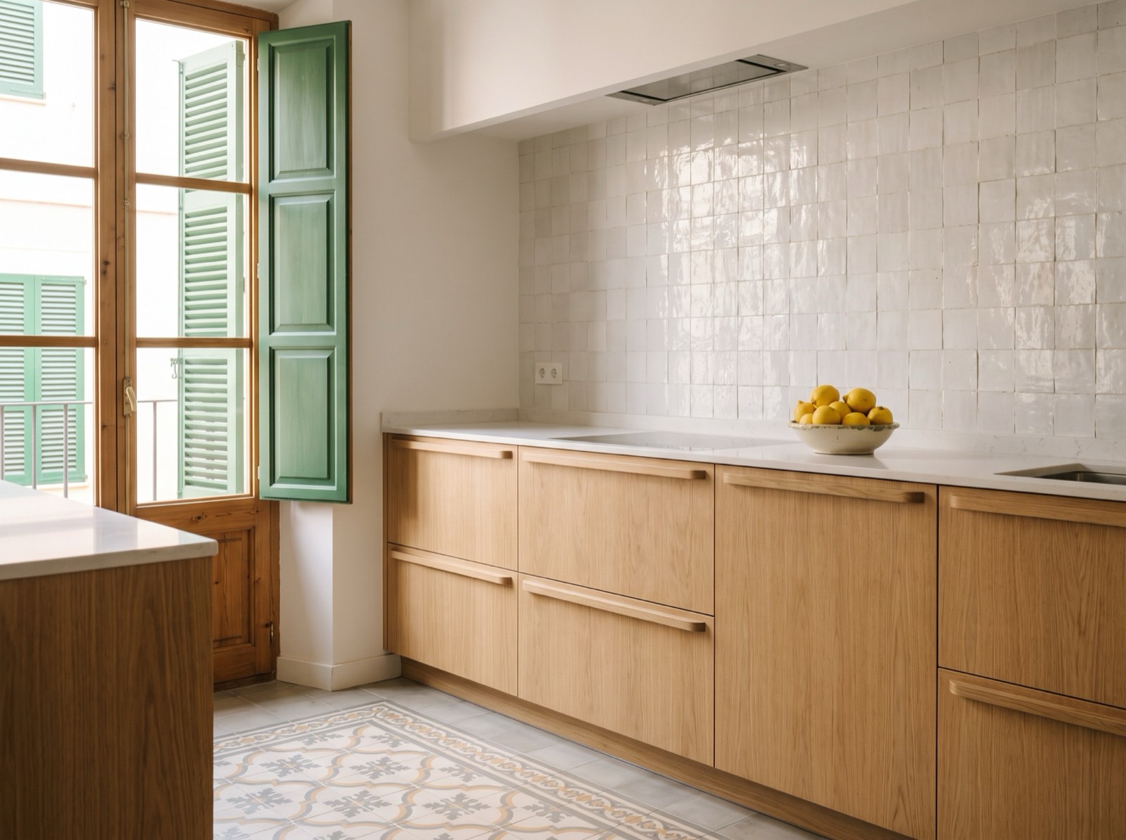 Cocina reformada con baldosa hidráulica y contraventanas verdes